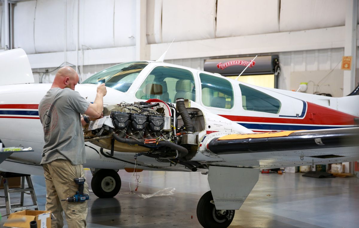 Technician working on the engine of a Beechcraft Bonanza